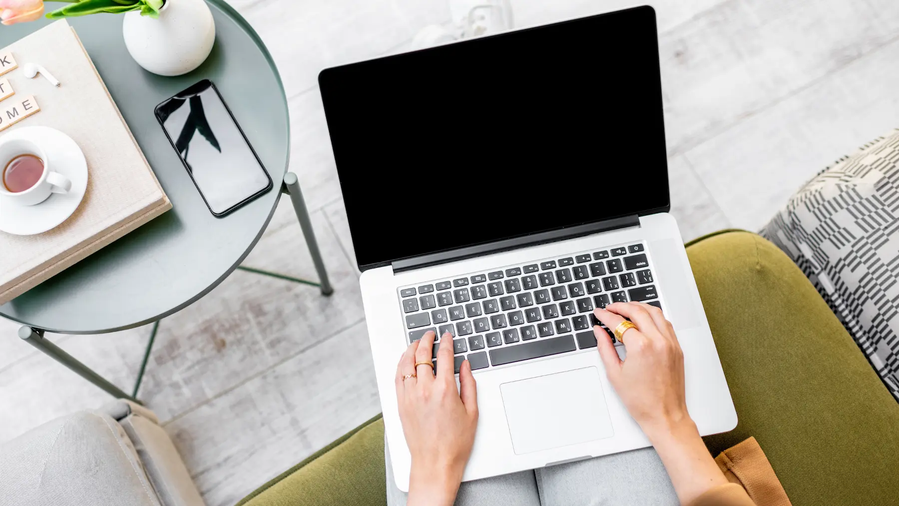 close up laptop in woman's lap with a small table nearby